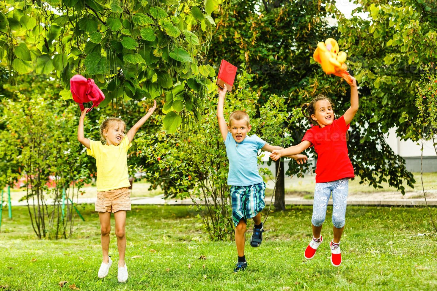 Three children at sunset jumping in the park photo