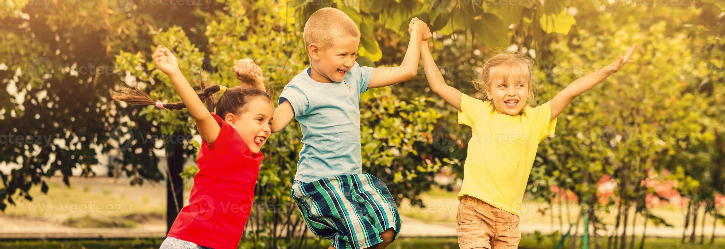 Large group of happy cheerful sportive children jumping and dancing. Childhood, freedom, happiness concept. photo