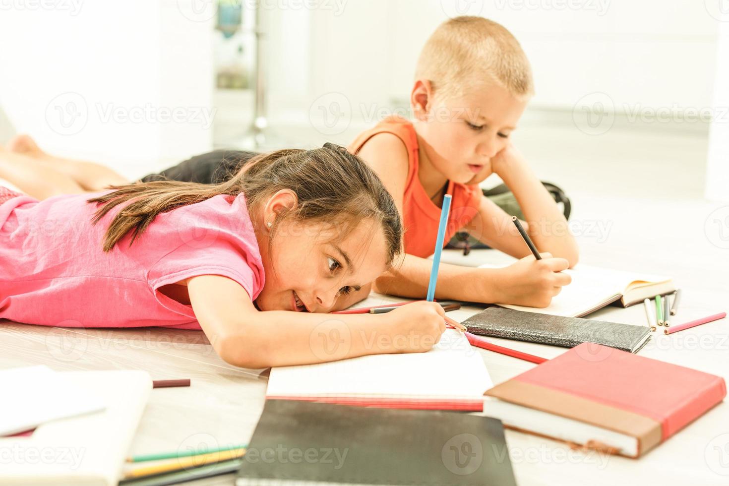 Two cute children draws on floor at home photo