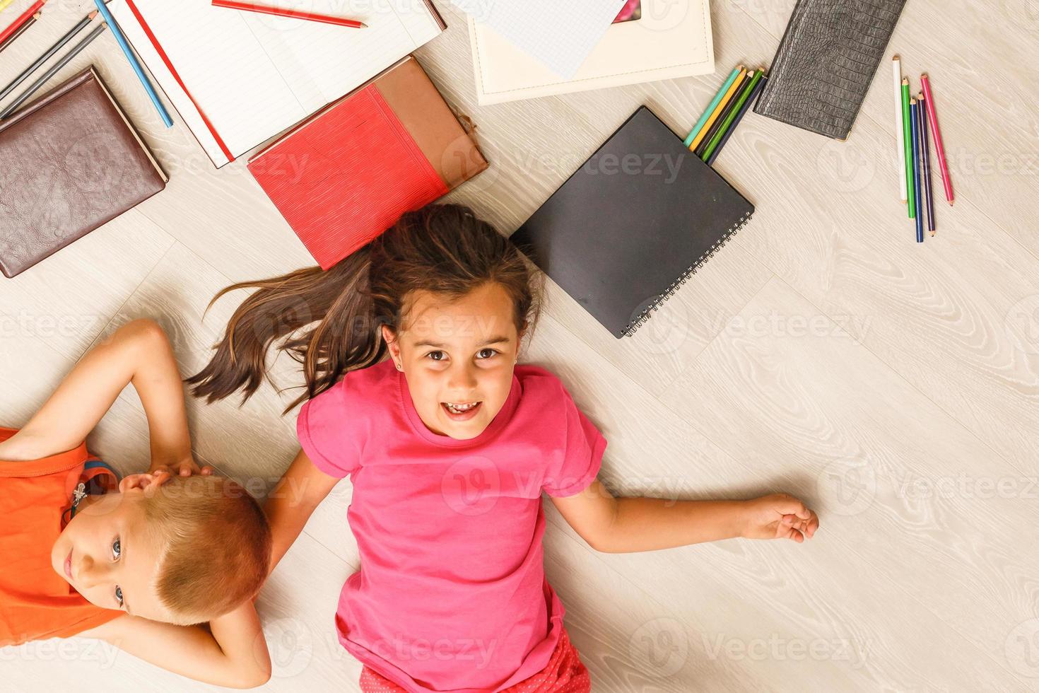 Kids reading for school lying on floor at home photo