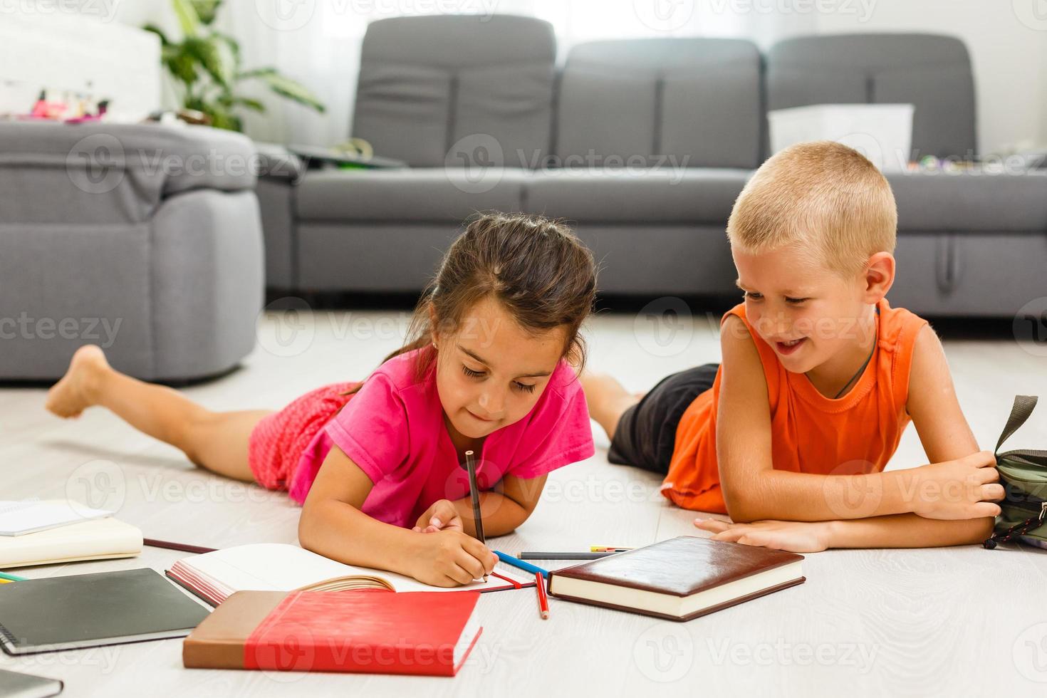 Brother and sister lying on the floor having fun photo