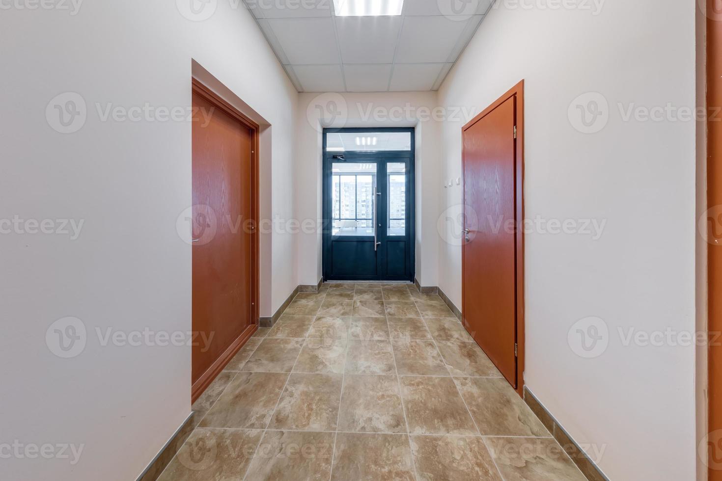 empty long corridor with red brick walls in interior of modern apartments, office or clinic. photo