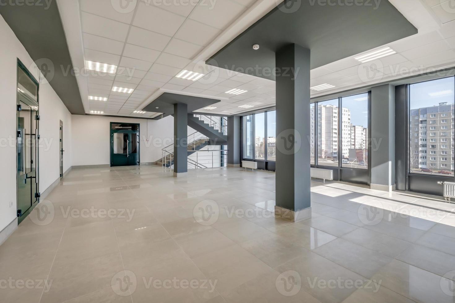 vacío moderno salón habitación con columnas, puertas y panorámico ventanas foto