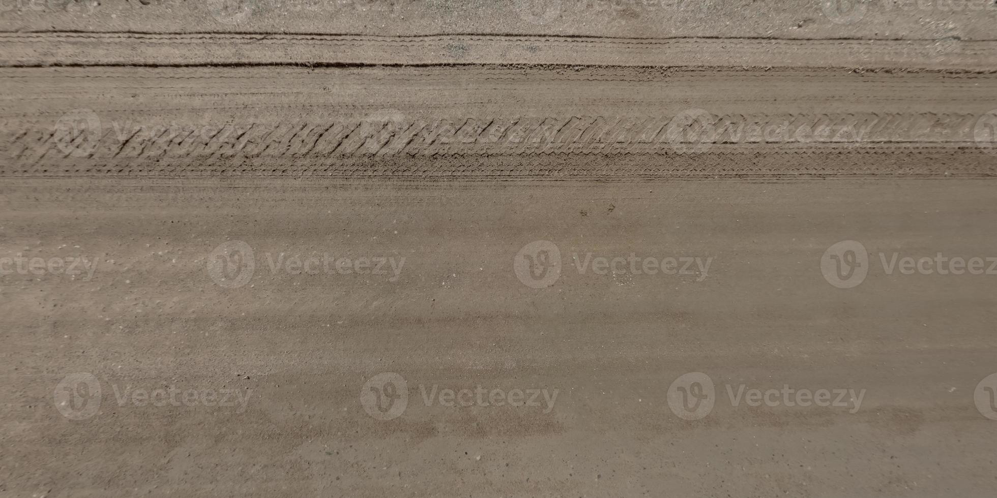 top view of surface of gravel road made of small stones and sand with traces of car tires photo