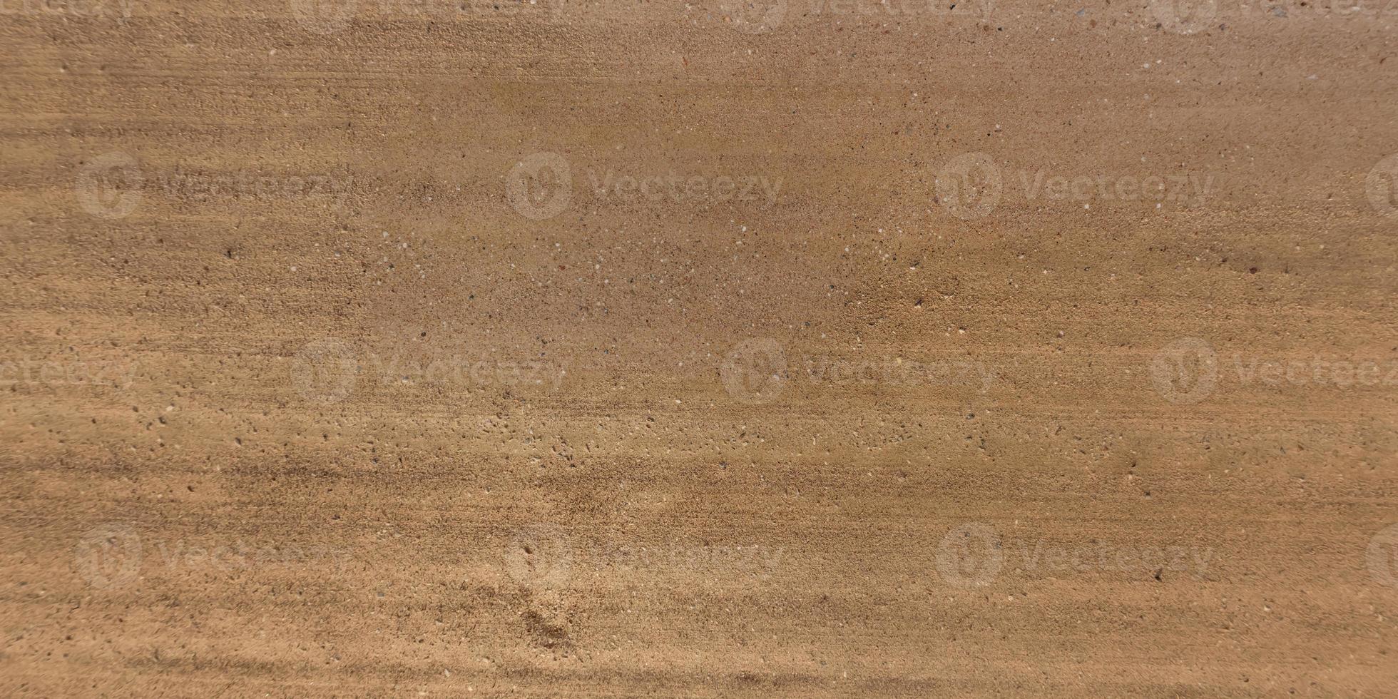 top view of surface of gravel road made of small stones and sand with traces of car tires photo