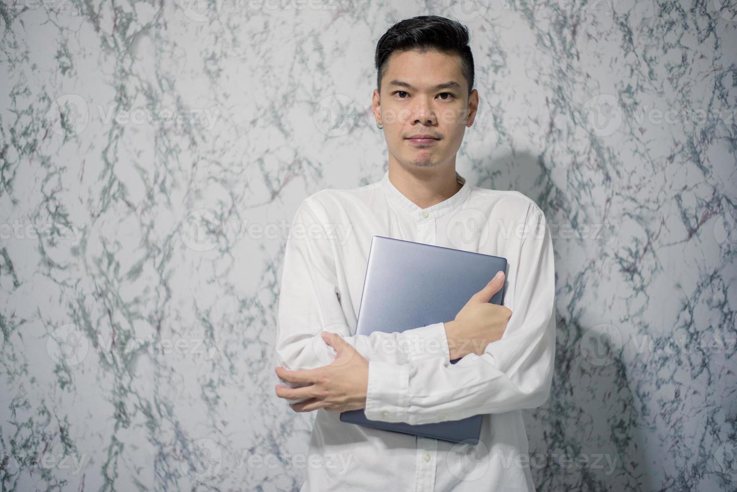 Handsome young smiling is holding a notebook and smiling at office photo