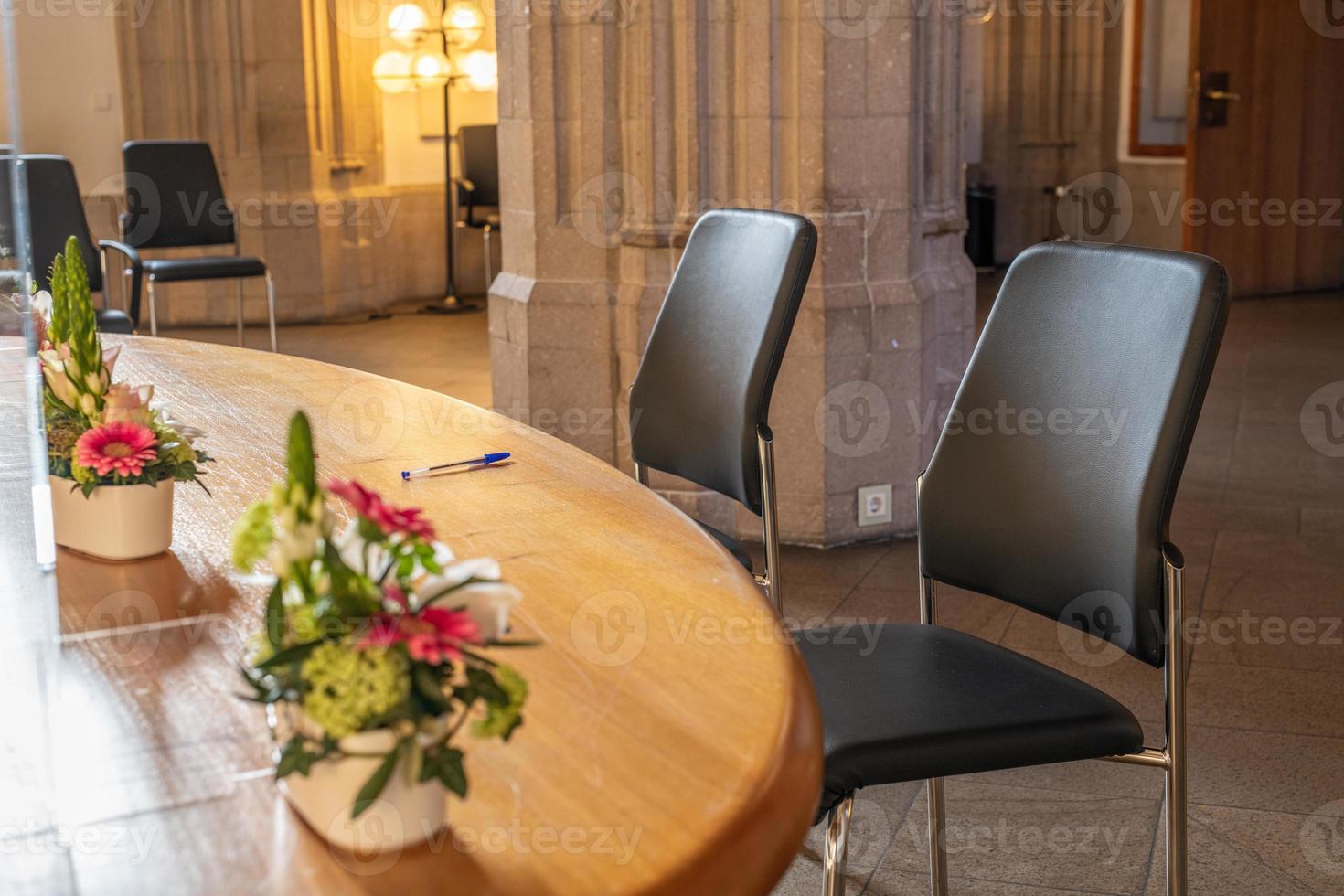 In the registry office 2 chairs a table and a pen photo