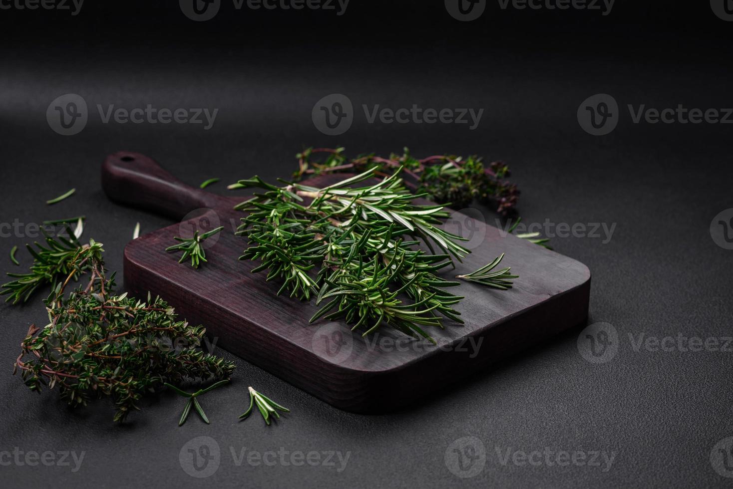 Sprigs of fresh green rosemary on a wooden cutting board photo