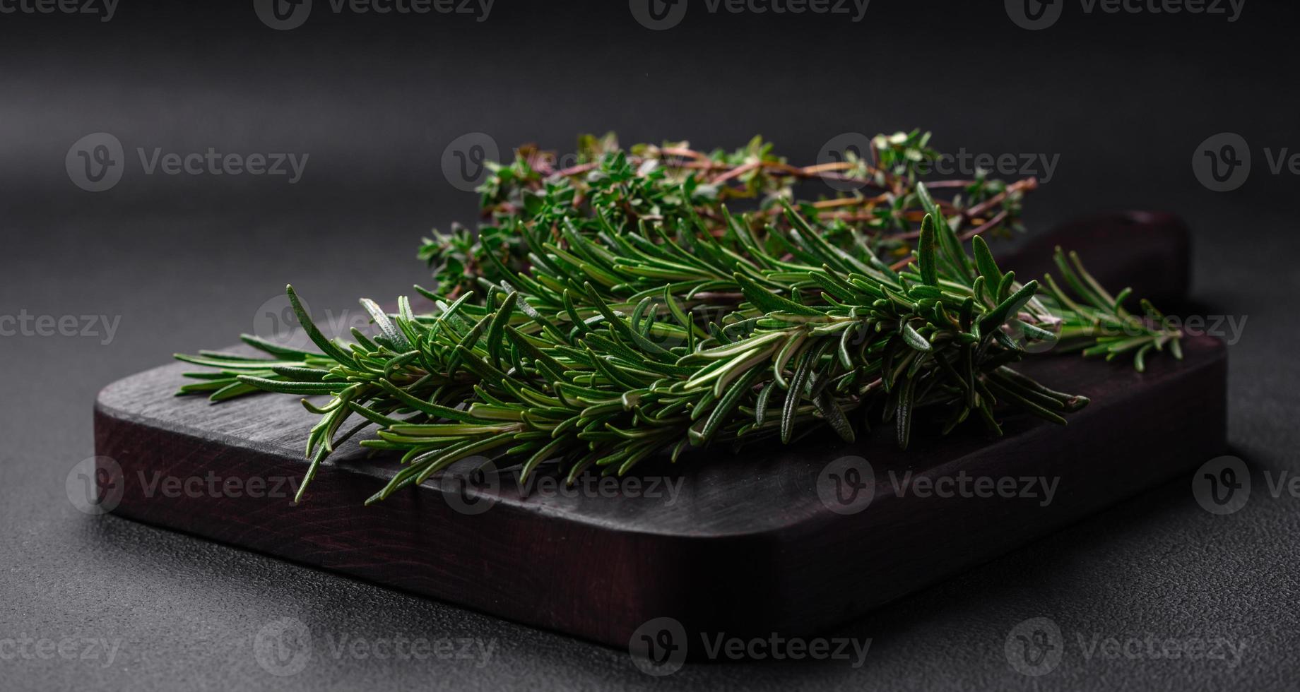Sprigs of fresh green rosemary on a wooden cutting board photo