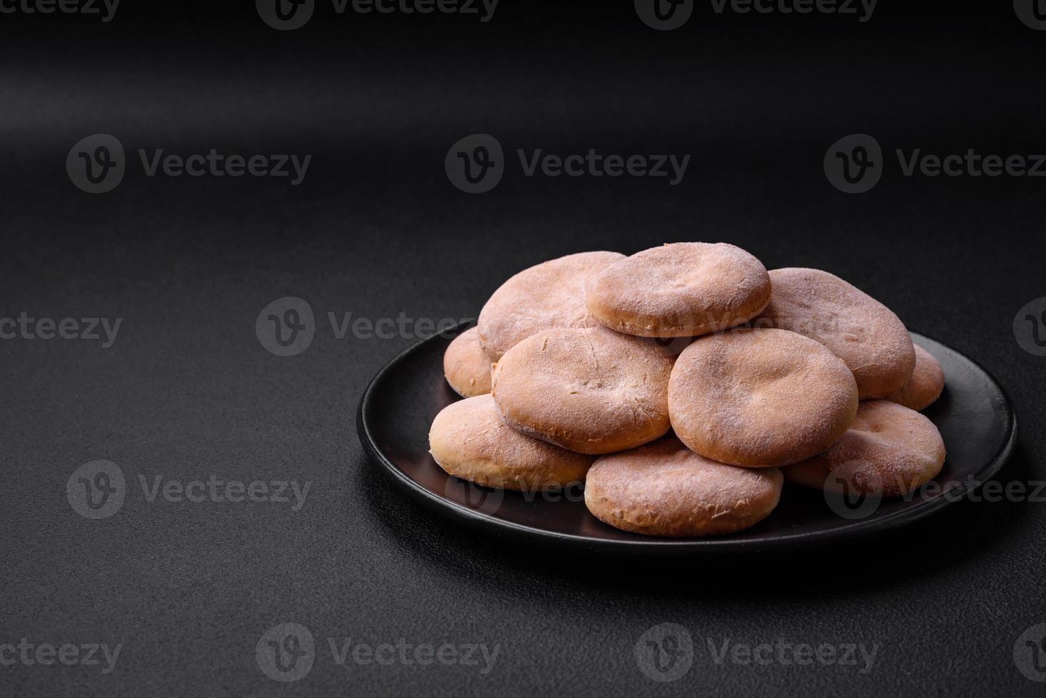 delicioso Fresco horneado harina de maíz tortas o galletas en un negro plato foto