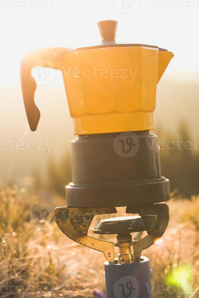 Close up camping kettle on gas burner in sunshine concept photo