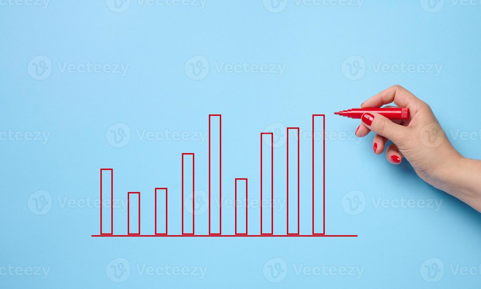 gráfico con indicadores de crecimiento y una mano femenina con un marcador sobre un fondo azul. el concepto de ventas exitosas en negocios, inflación y aumento de precios foto