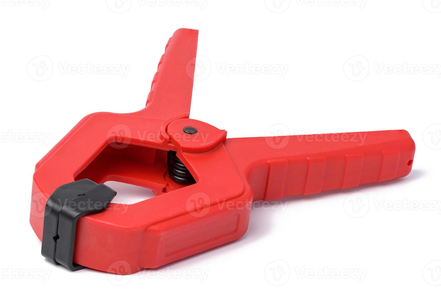 Large  red plastic clamp on a white isolated background photo