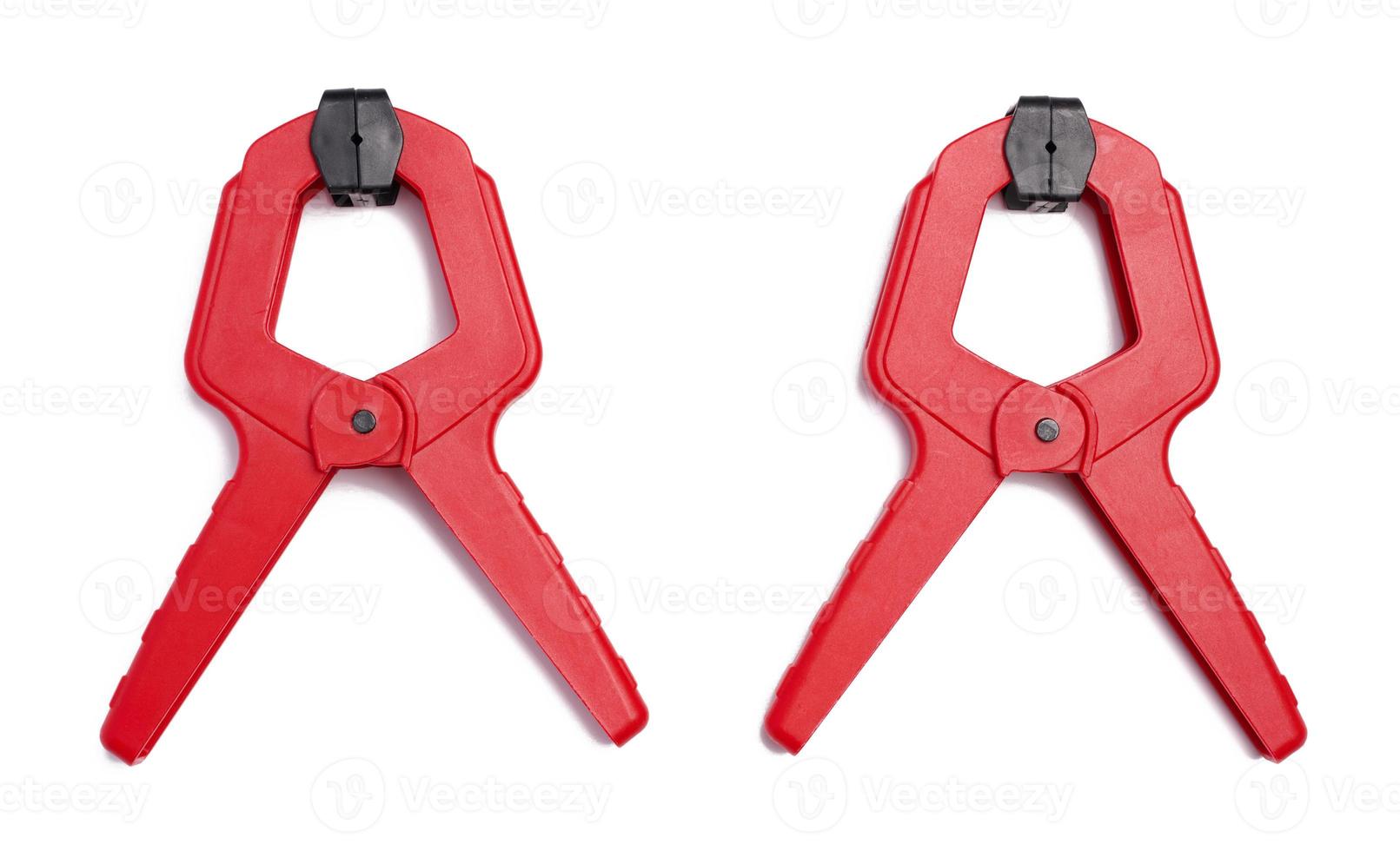 Large  red plastic clamp on a white isolated background photo