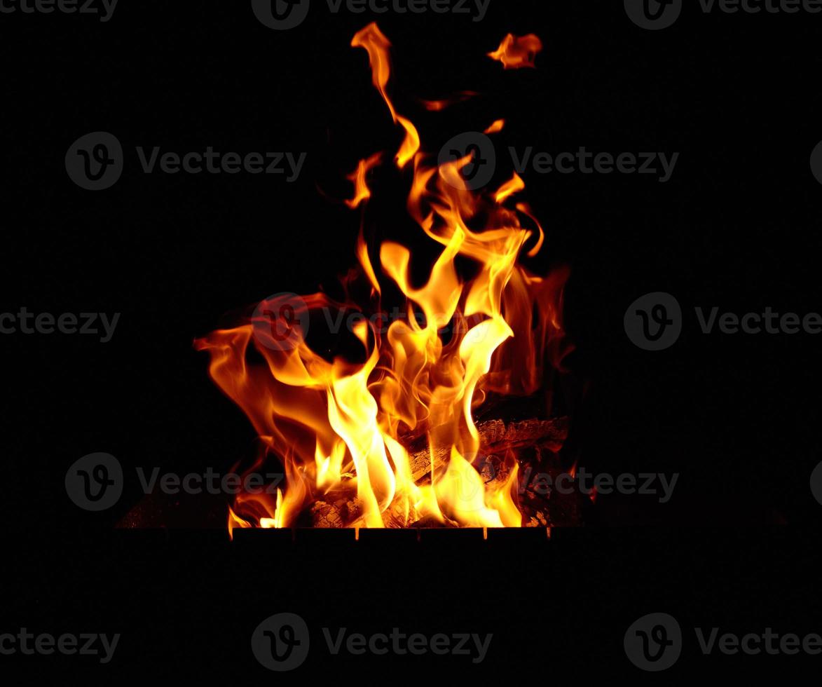 burning bonfire with logs and large orange flames at night photo