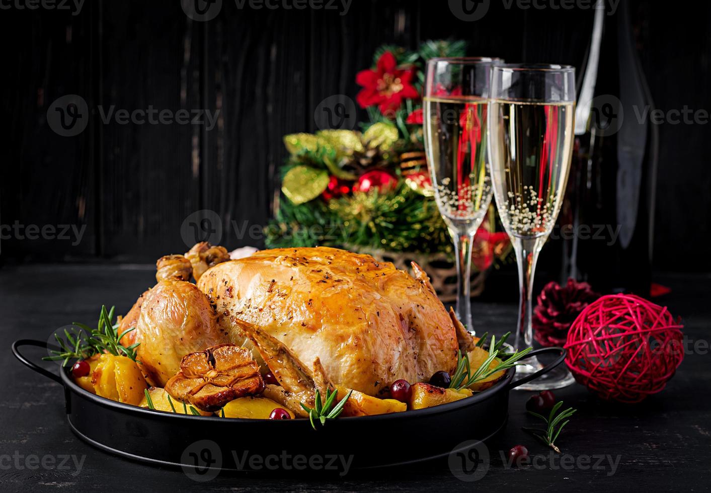 Baked turkey or chicken. The Christmas table is served with a turkey, decorated with bright tinsel. Fried chicken, table setting. Christmas dinner. photo