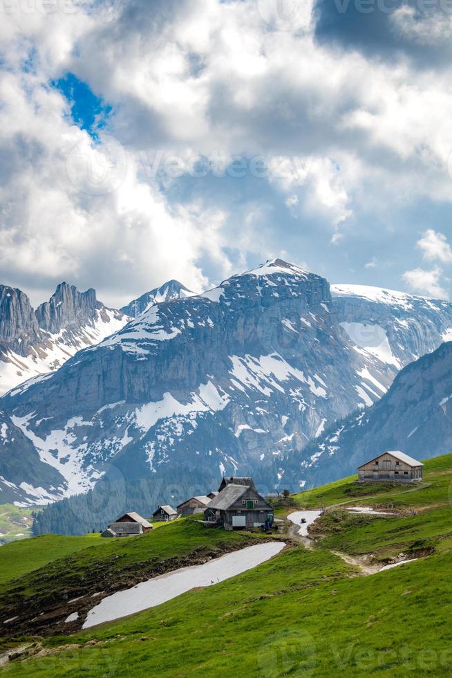 A farm on the mountains in the background you can see a mountain range in cloudy weather photo