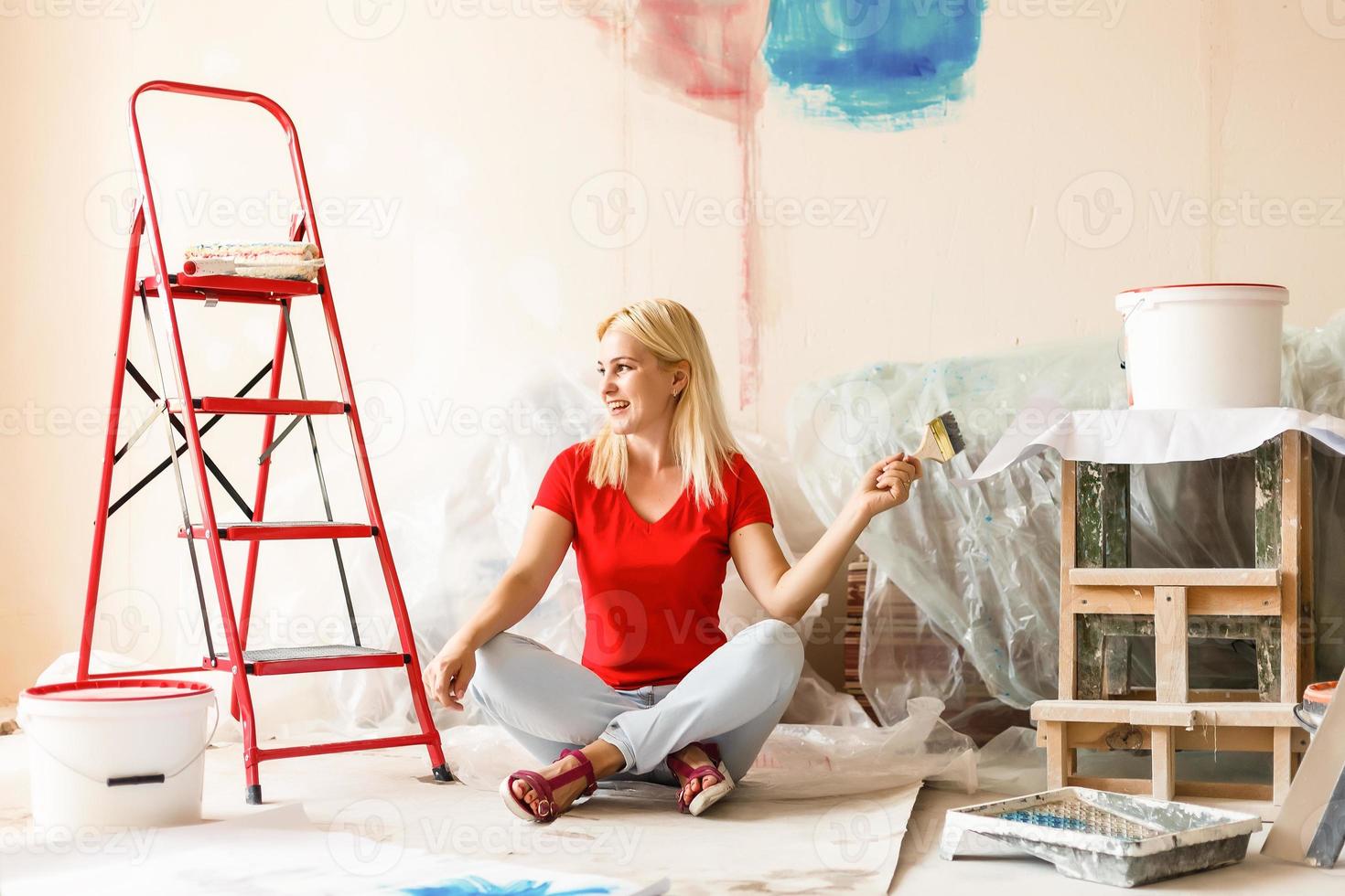 Happy woman paint wall at home. photo