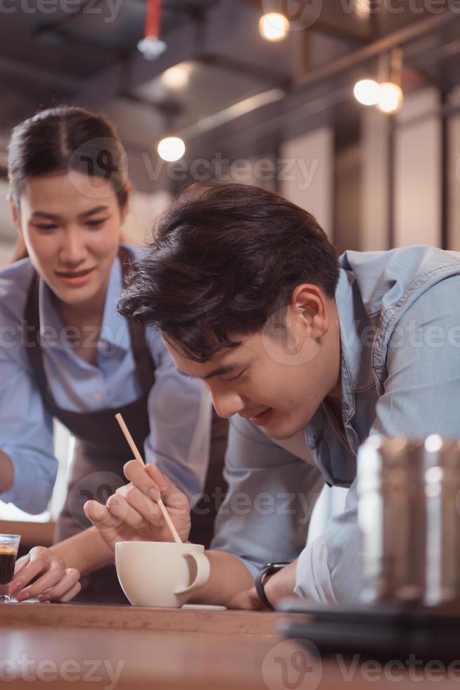 Before competing in the championship level coffee brewing competition, both of the baristas practice their coffee latte makeup techniques to become proficient. photo