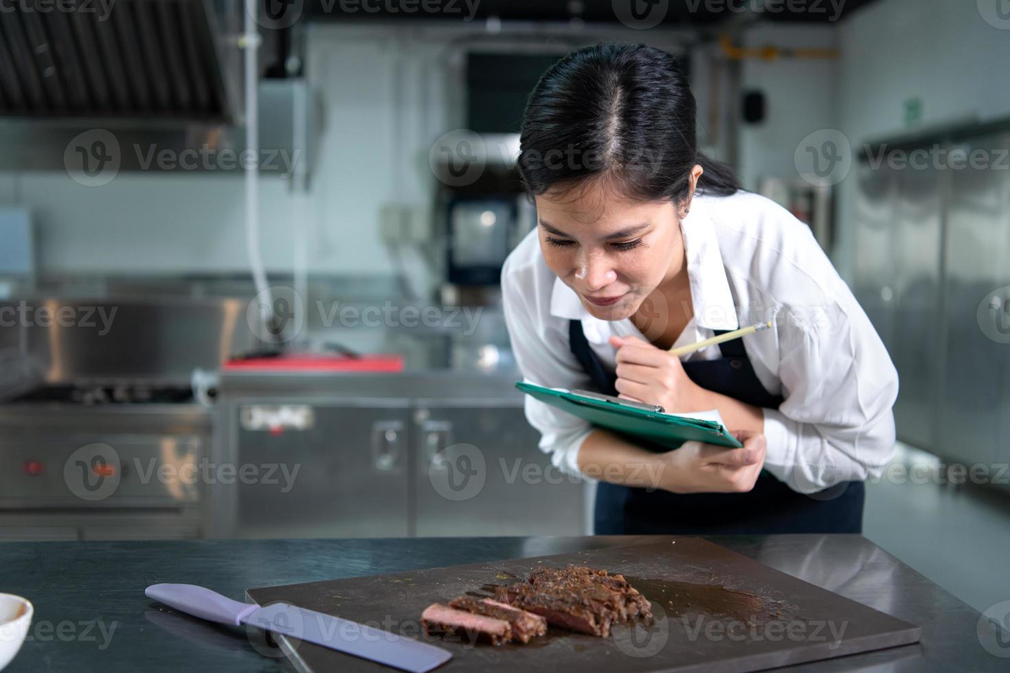 retrato de estudiante Cocinando aprendiz tomar notas en cada paso como el cocinero cocineros en el culinario de la academia cocina. foto