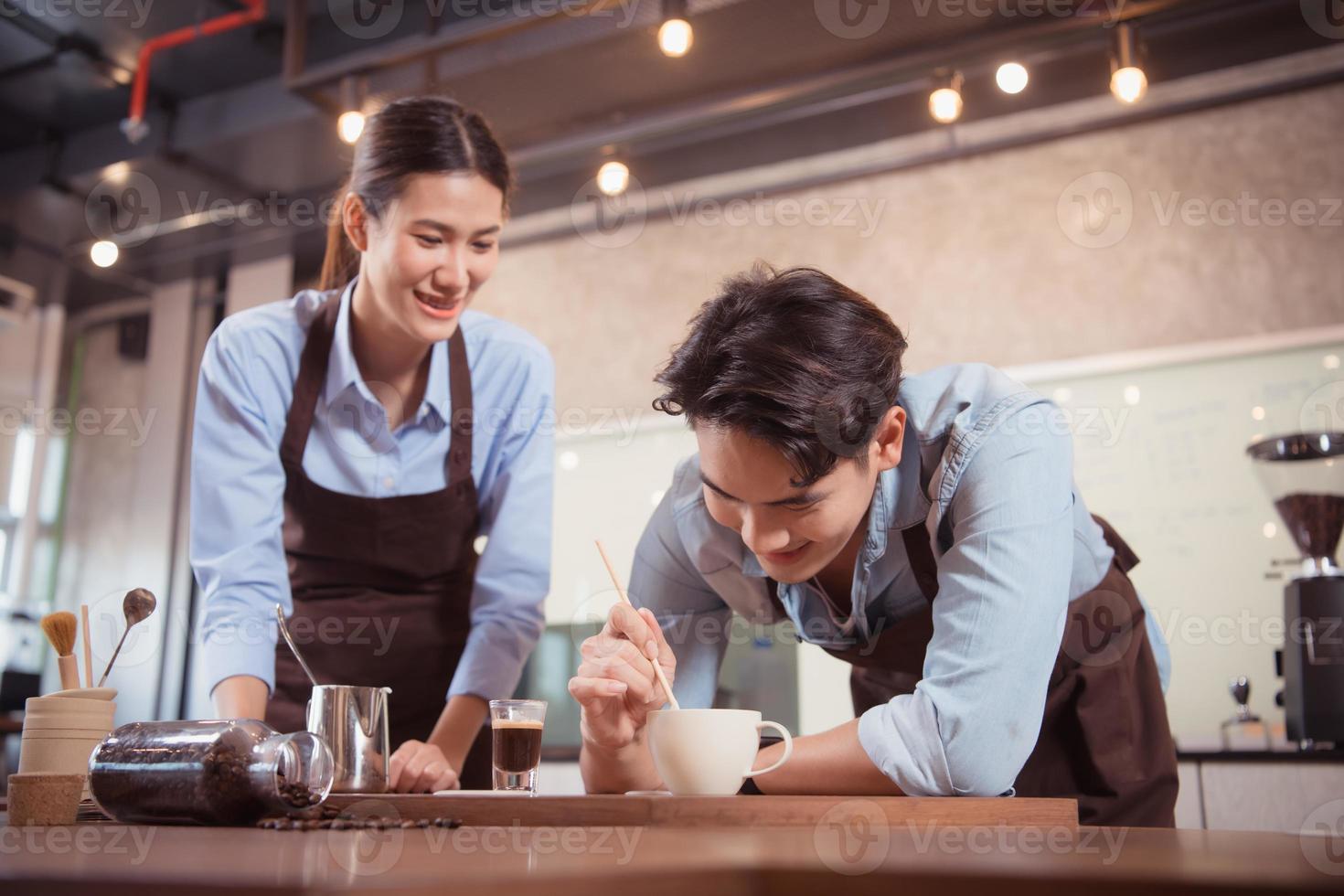 Before competing in the championship level coffee brewing competition, both of the baristas practice their coffee latte makeup techniques to become proficient. photo
