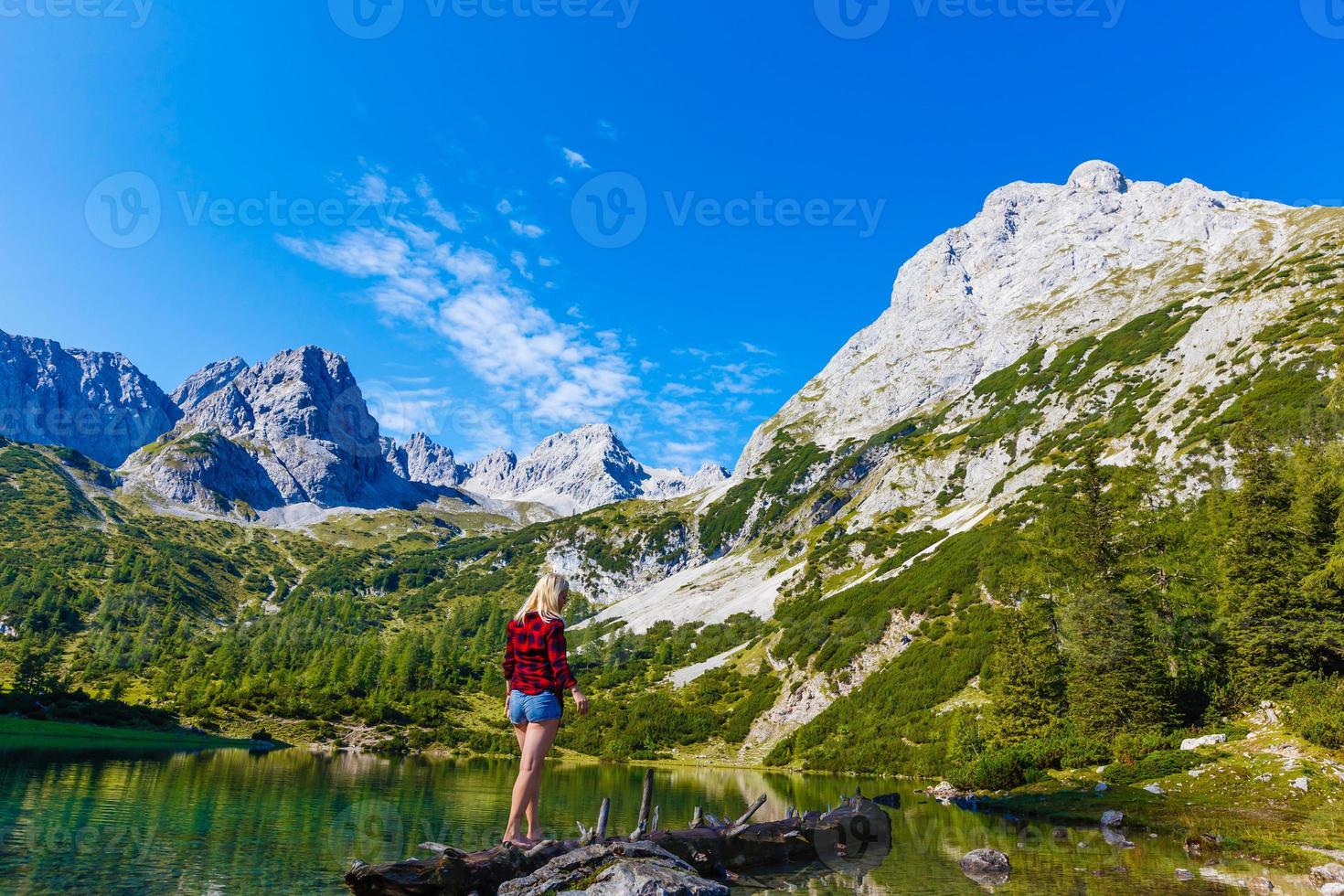 woman enjoying beauty of nature looking at mountain. Adventure travel, Europe. Woman stands on background with Alps. photo