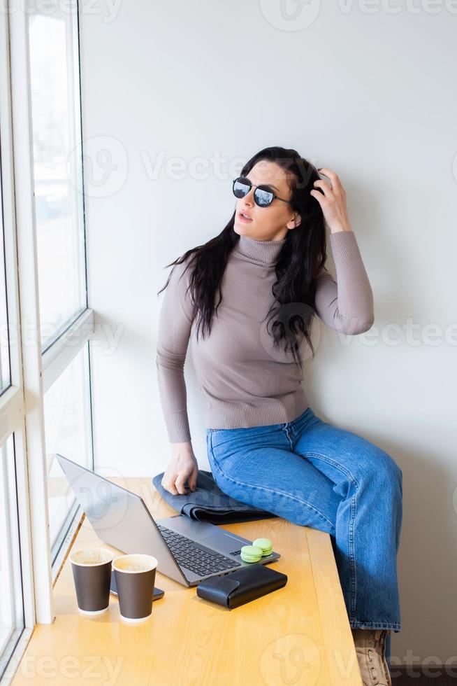 Beautiful businesswoman working on a laptop. Female freelancer connecting to internet via computer. Blogger or journalist writing new article. photo