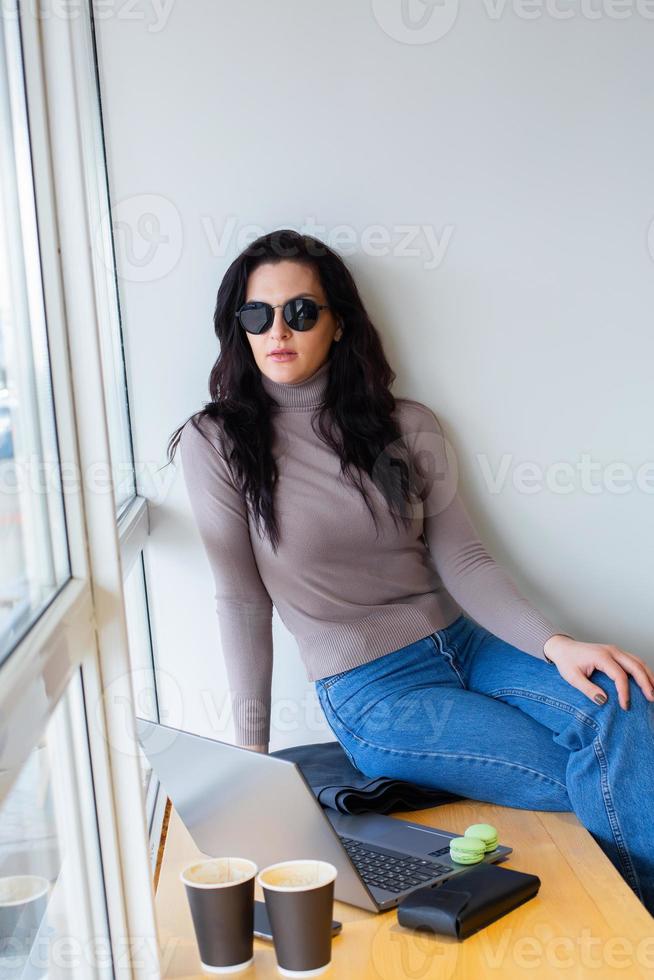 Beautiful businesswoman working on a laptop. Female freelancer connecting to internet via computer. Blogger or journalist writing new article. photo