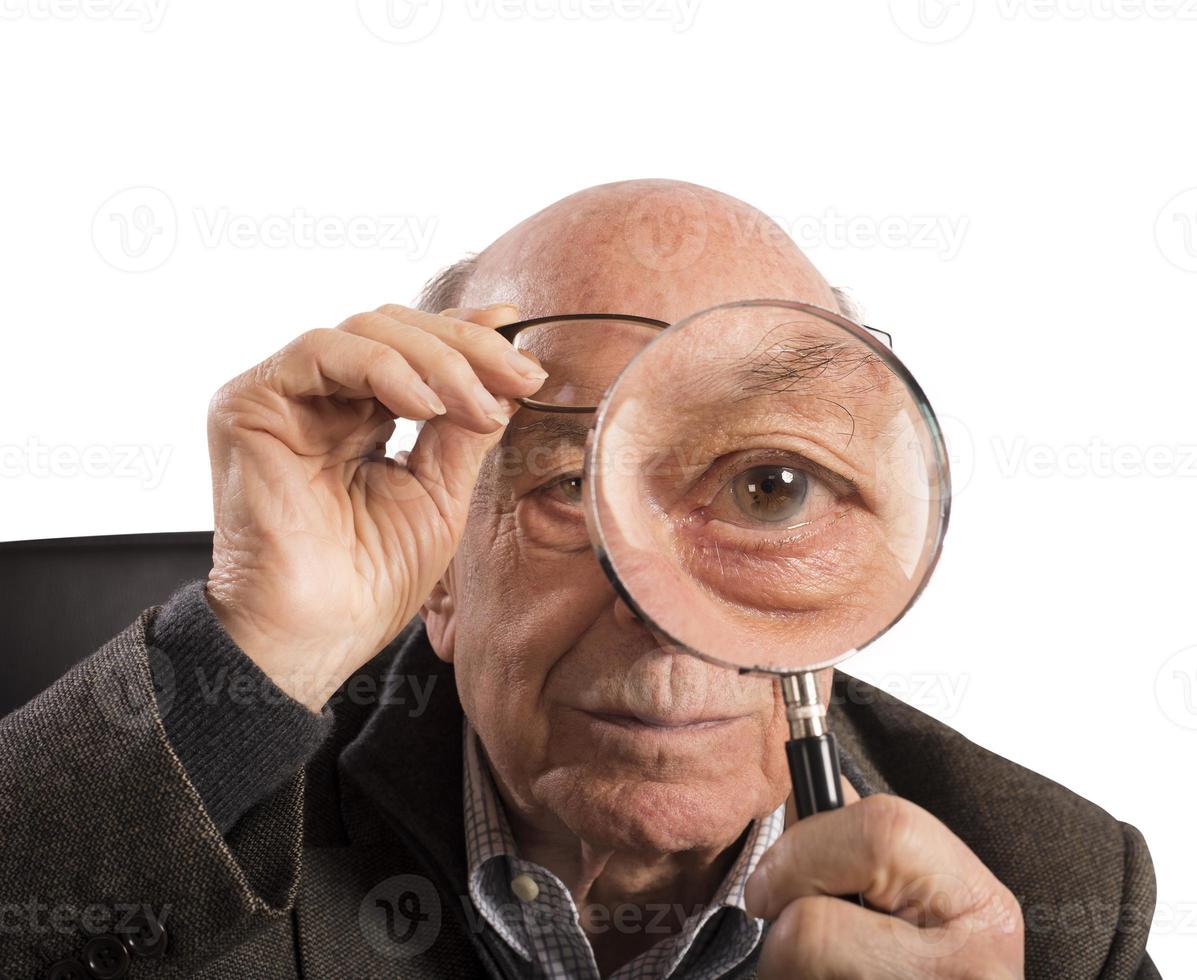 Older man with magnifying glass photo