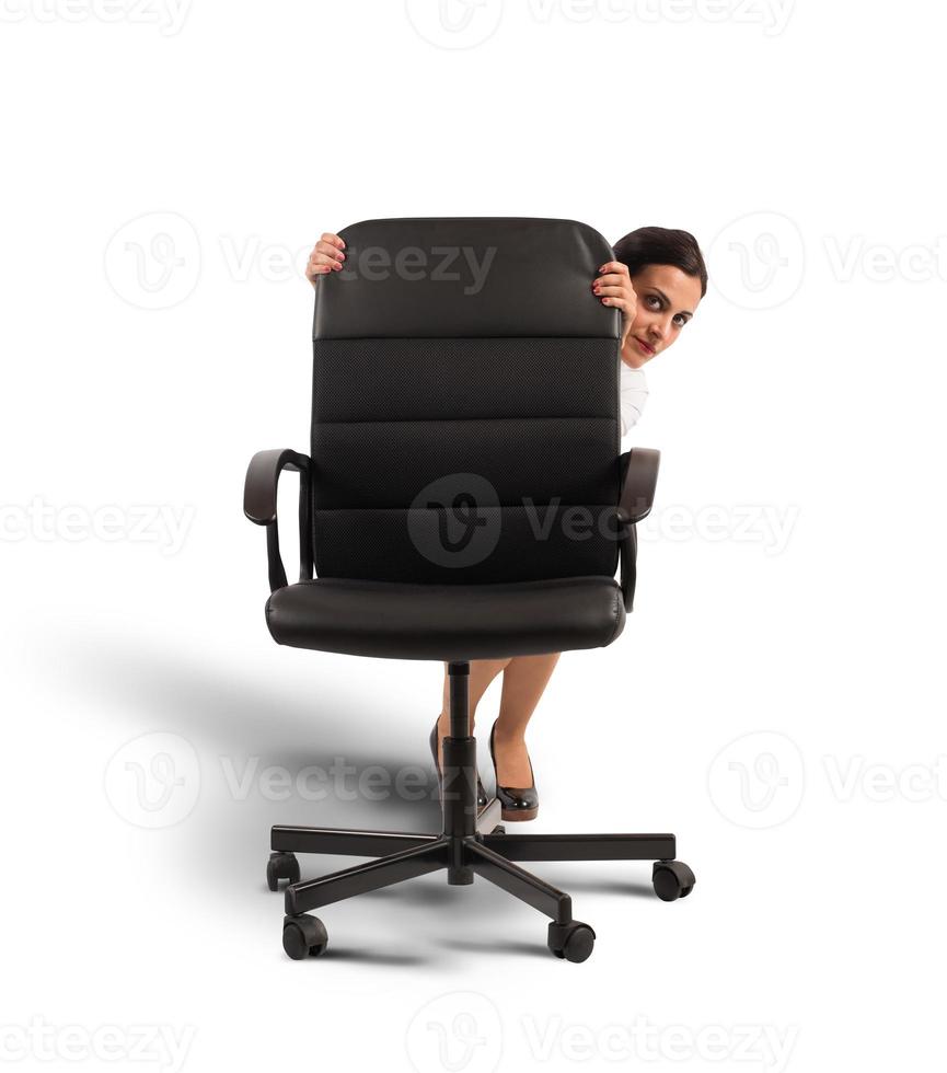 Businesswoman hiding behind a chair photo