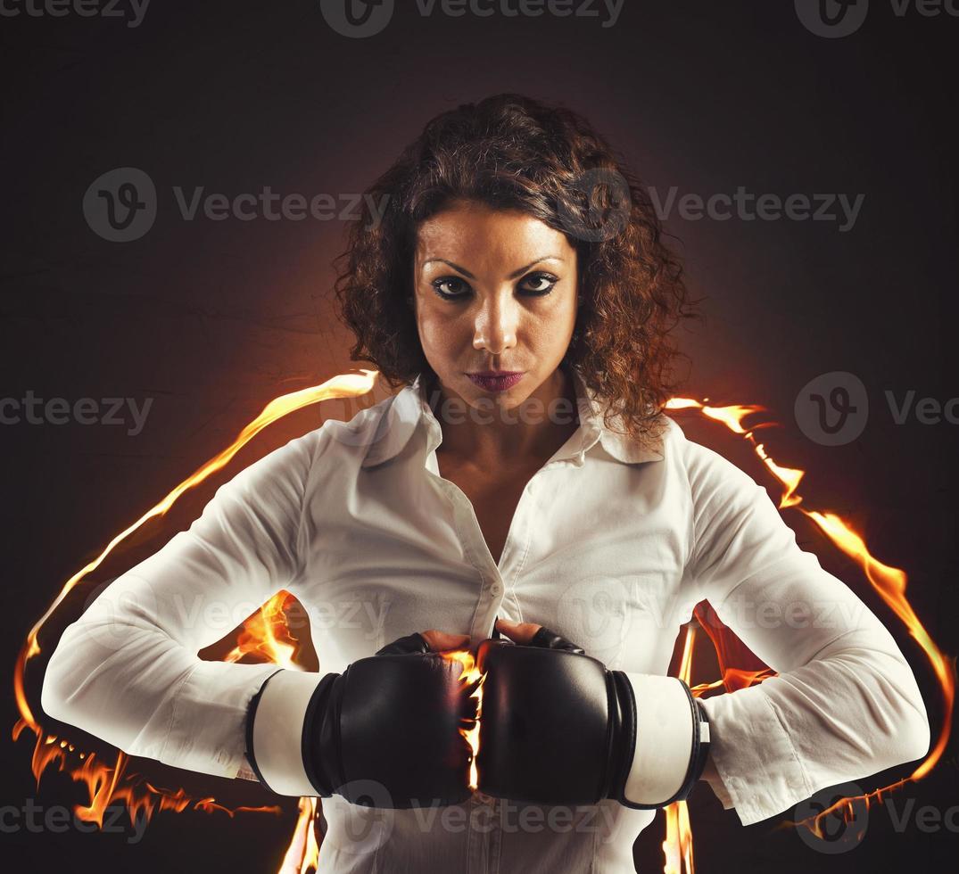 Determined businesswoman with boxing gloves photo