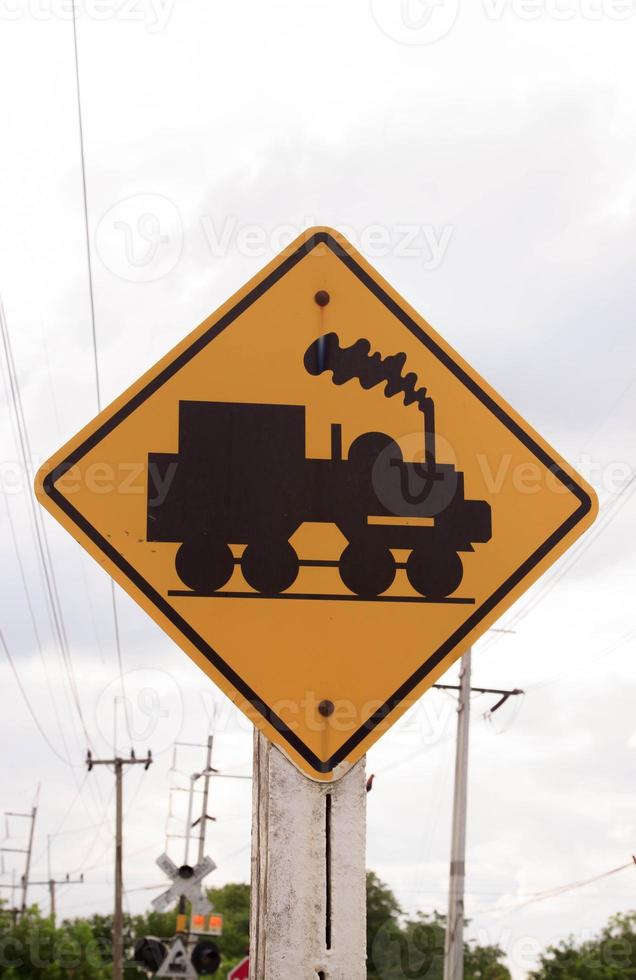 Traffic sign, watch out for the train. Drive slowly and watch out for the way ahead. There is a train passing by on rural roads of Thailand and the beautiful blue sky in the countryside. photo