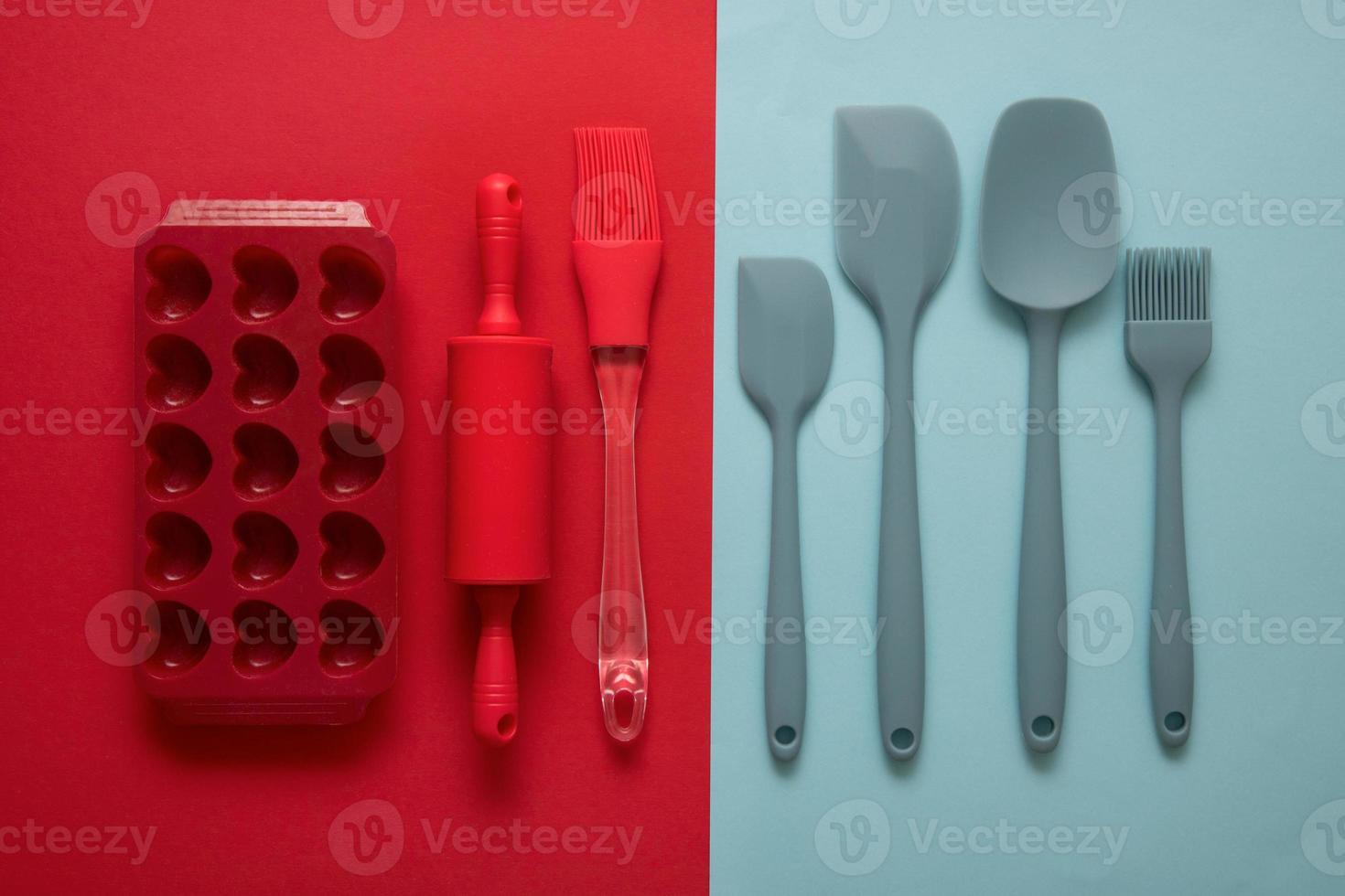 silicone culinary accessories spatulas, brushes, shape, rolling pin on red and blue background, culinary background photo