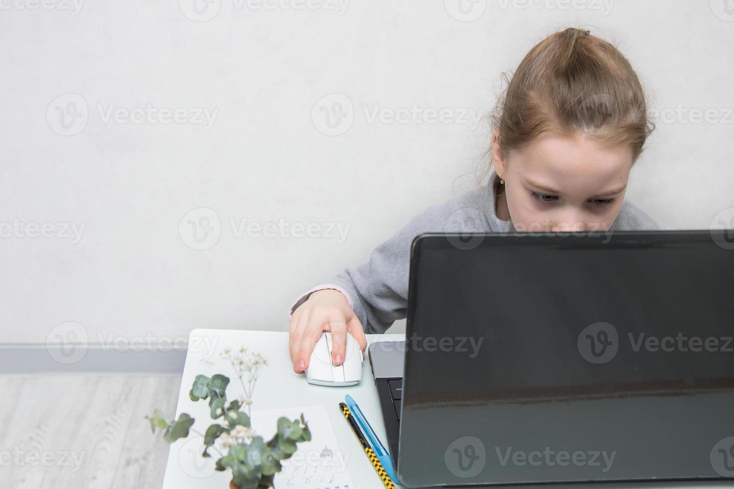 little one is doing tasks in a laptop with concentration, back to school photo
