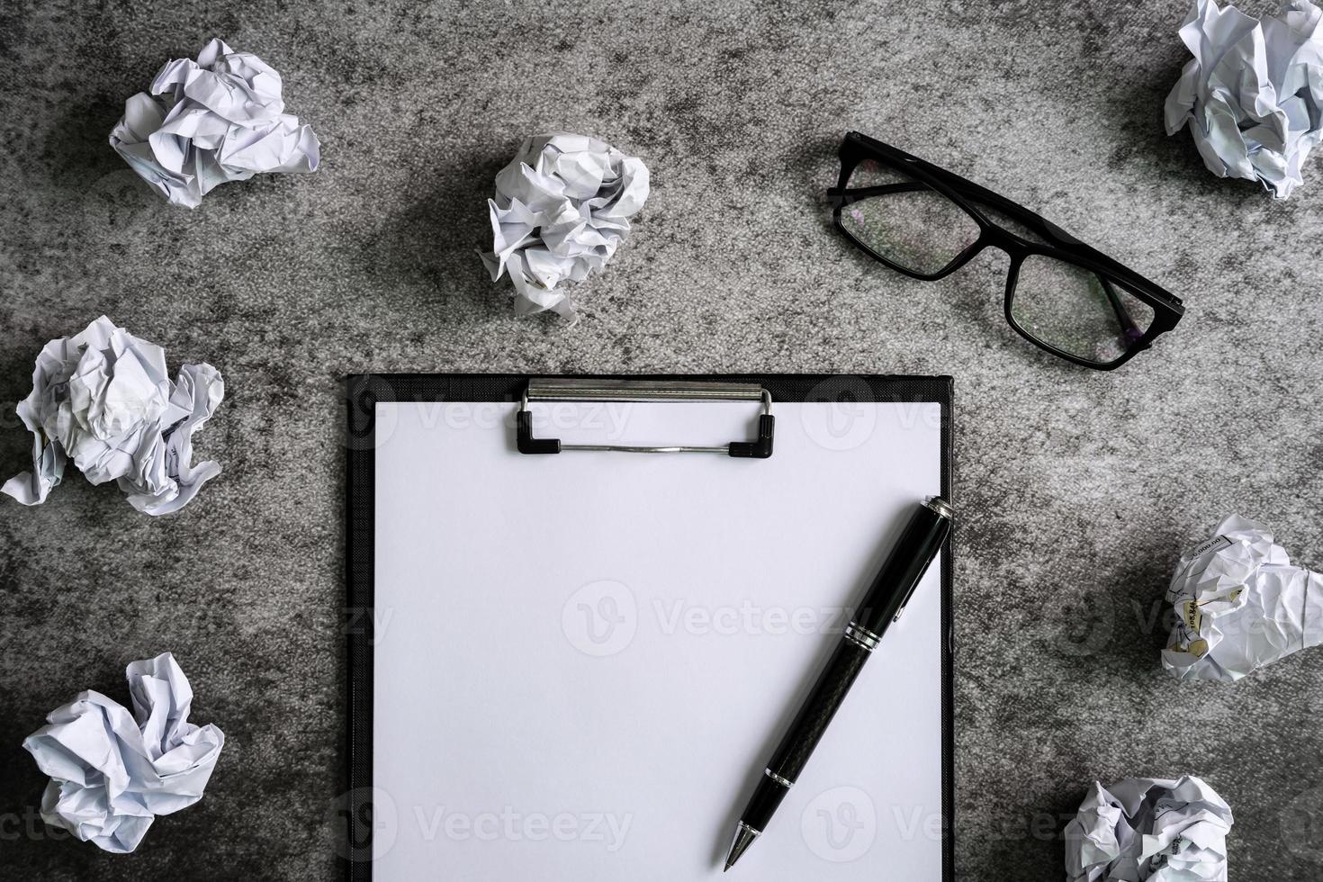 Crumpled paper balls with eye glasses and file folder on desk office, Creativity problems concept photo