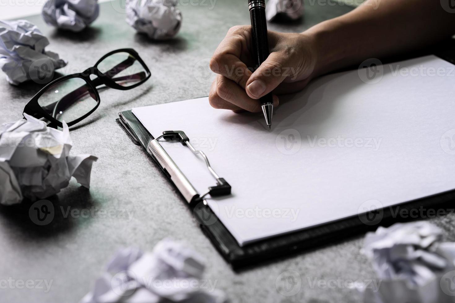 Hand writing on file folder with crumpled paper balls on desk office, Creativity problems concept photo