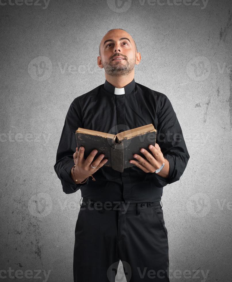 Priest praying with bible photo