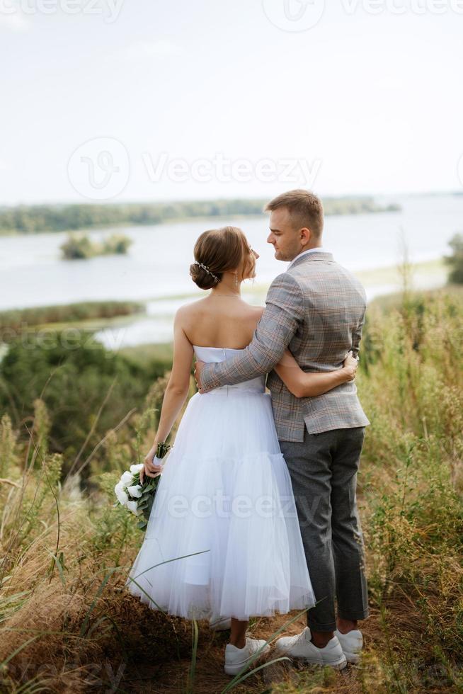 young couple a guy and a girl are walking in the green hills photo