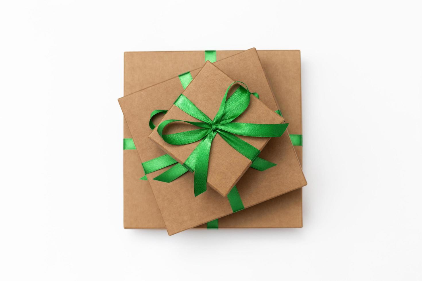 Top view of craft present boxes with green ribbons on the white background photo