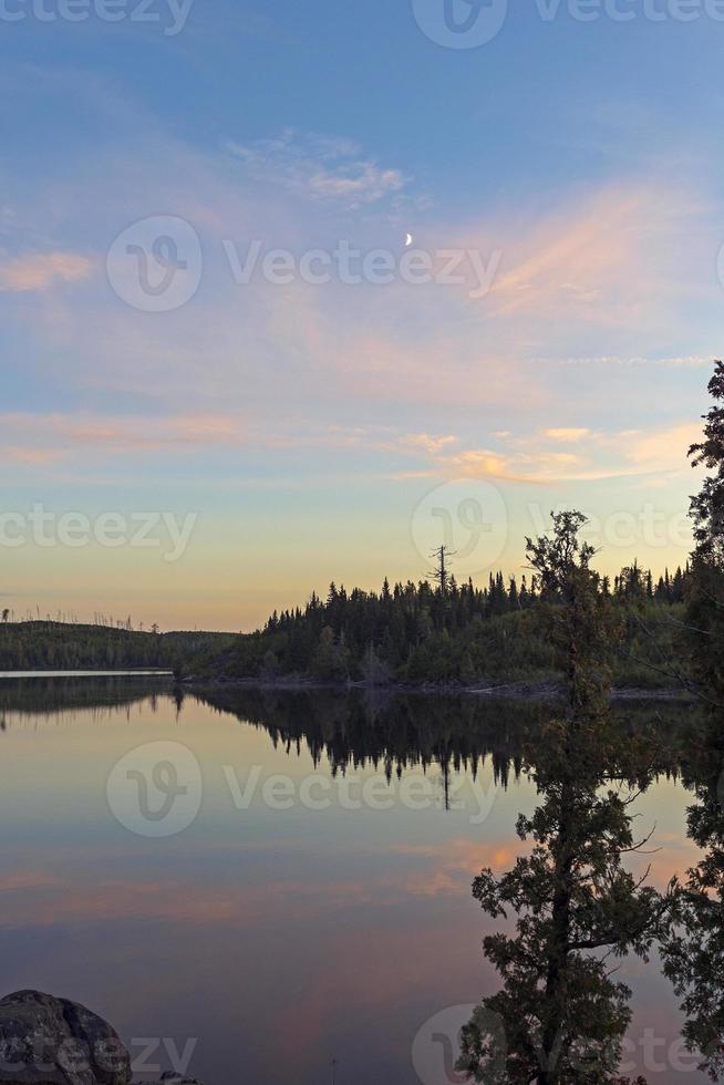 Clouds and Moon on Calm Lake at Dusk photo