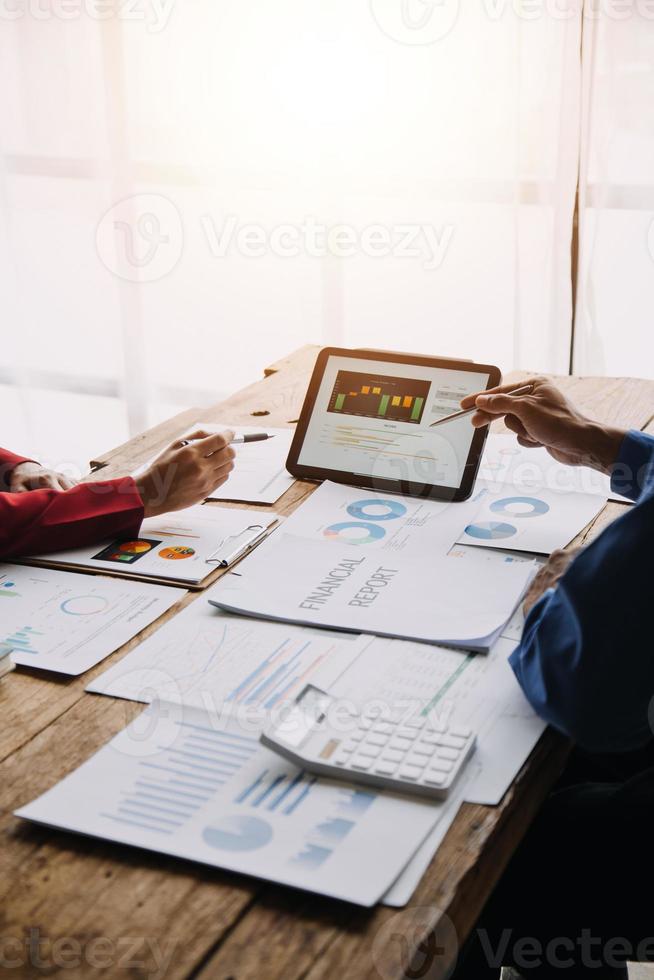 Group of confident business people point to graphs and charts to analyze market data, balance sheet, account, net profit to plan new sales strategies to increase production capacity. photo