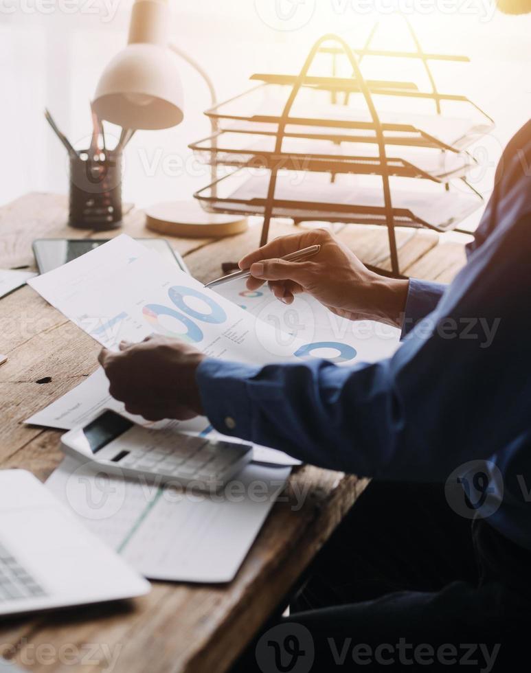 Group of confident business people point to graphs and charts to analyze market data, balance sheet, account, net profit to plan new sales strategies to increase production capacity. photo