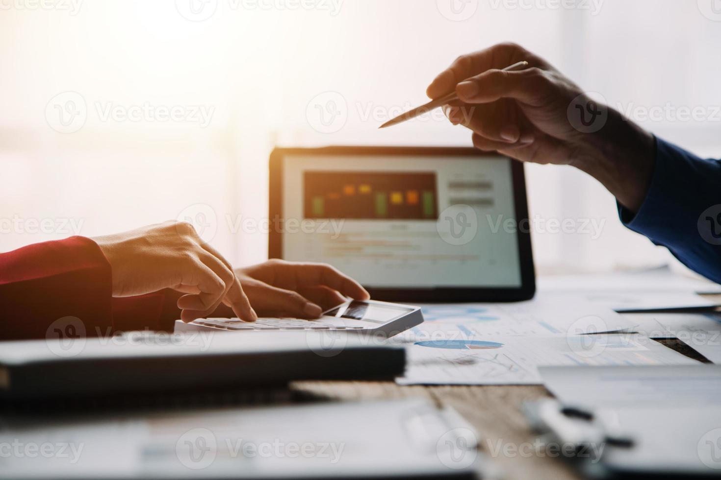 Group of confident business people point to graphs and charts to analyze market data, balance sheet, account, net profit to plan new sales strategies to increase production capacity. photo