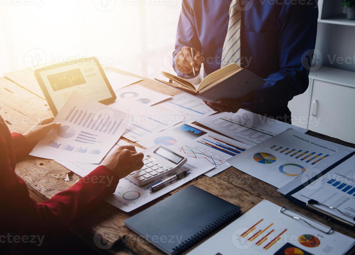 Group of confident business people point to graphs and charts to analyze market data, balance sheet, account, net profit to plan new sales strategies to increase production capacity. photo