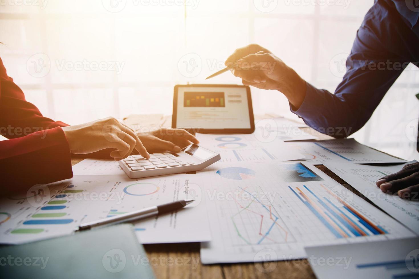 Group of confident business people point to graphs and charts to analyze market data, balance sheet, account, net profit to plan new sales strategies to increase production capacity. photo