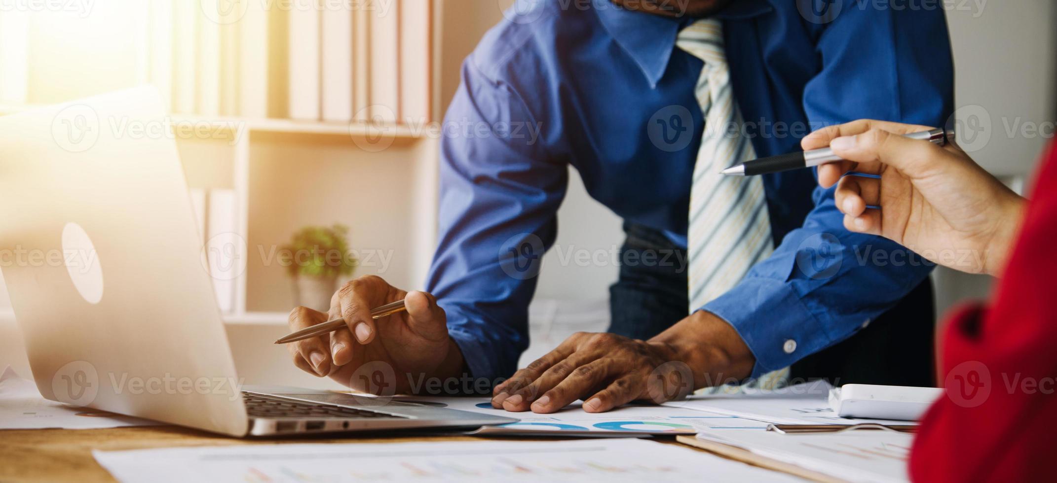 Group of confident business people point to graphs and charts to analyze market data, balance sheet, account, net profit to plan new sales strategies to increase production capacity. photo