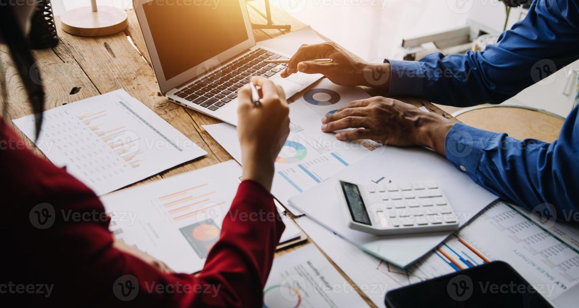 Group of confident business people point to graphs and charts to analyze market data, balance sheet, account, net profit to plan new sales strategies to increase production capacity. photo