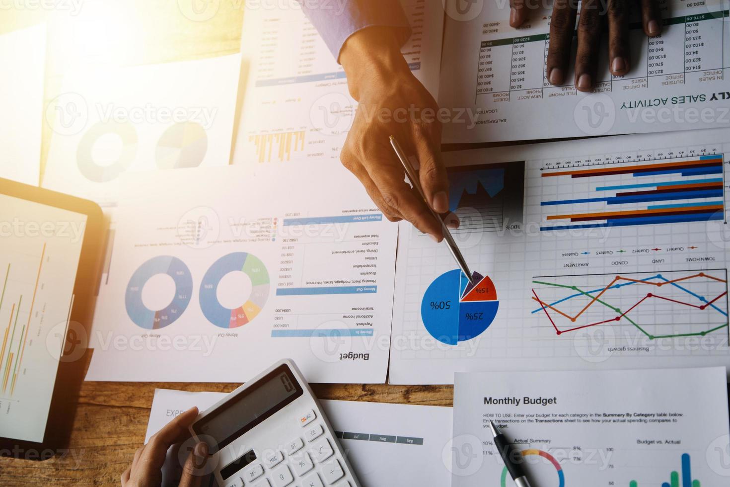 Group of confident business people point to graphs and charts to analyze market data, balance sheet, account, net profit to plan new sales strategies to increase production capacity. photo