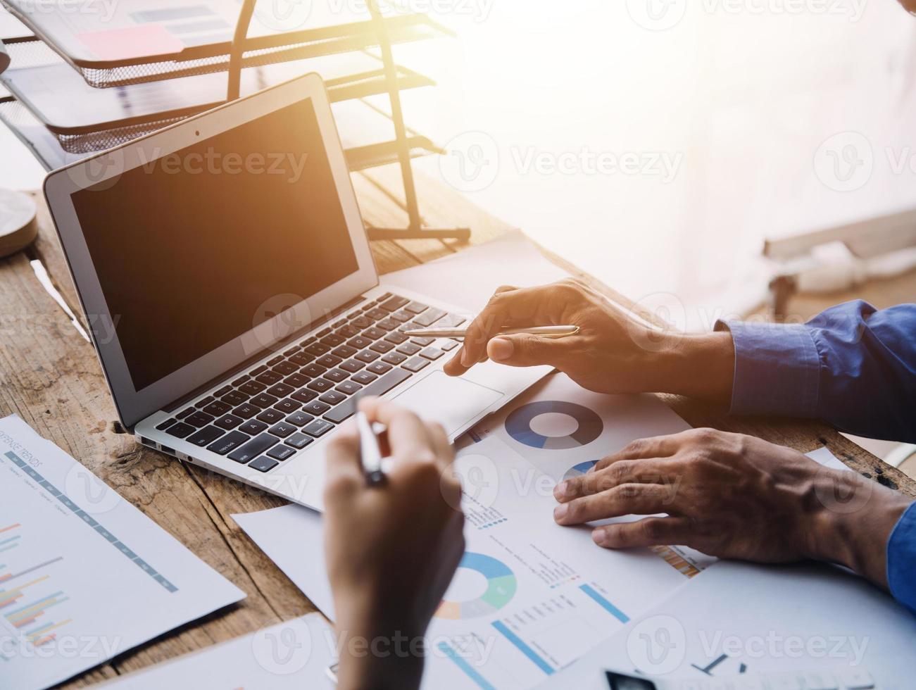 Group of confident business people point to graphs and charts to analyze market data, balance sheet, account, net profit to plan new sales strategies to increase production capacity. photo