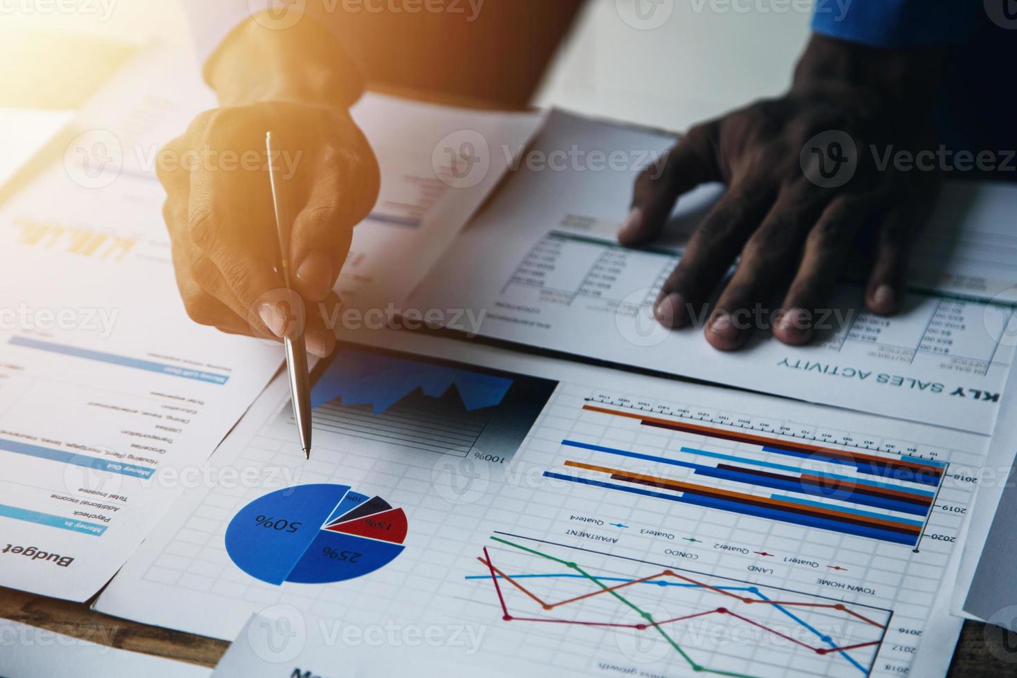 Group of confident business people point to graphs and charts to analyze market data, balance sheet, account, net profit to plan new sales strategies to increase production capacity. photo